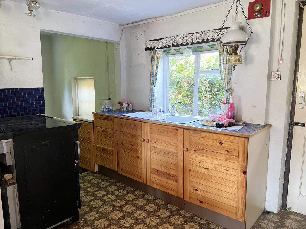 Lot: 65 - THREE-BEDROOM COTTAGE ON PLOT OF 0.34 ACRES FOR IMPROVEMENT - Kitchen with window to garden and utility room beyond